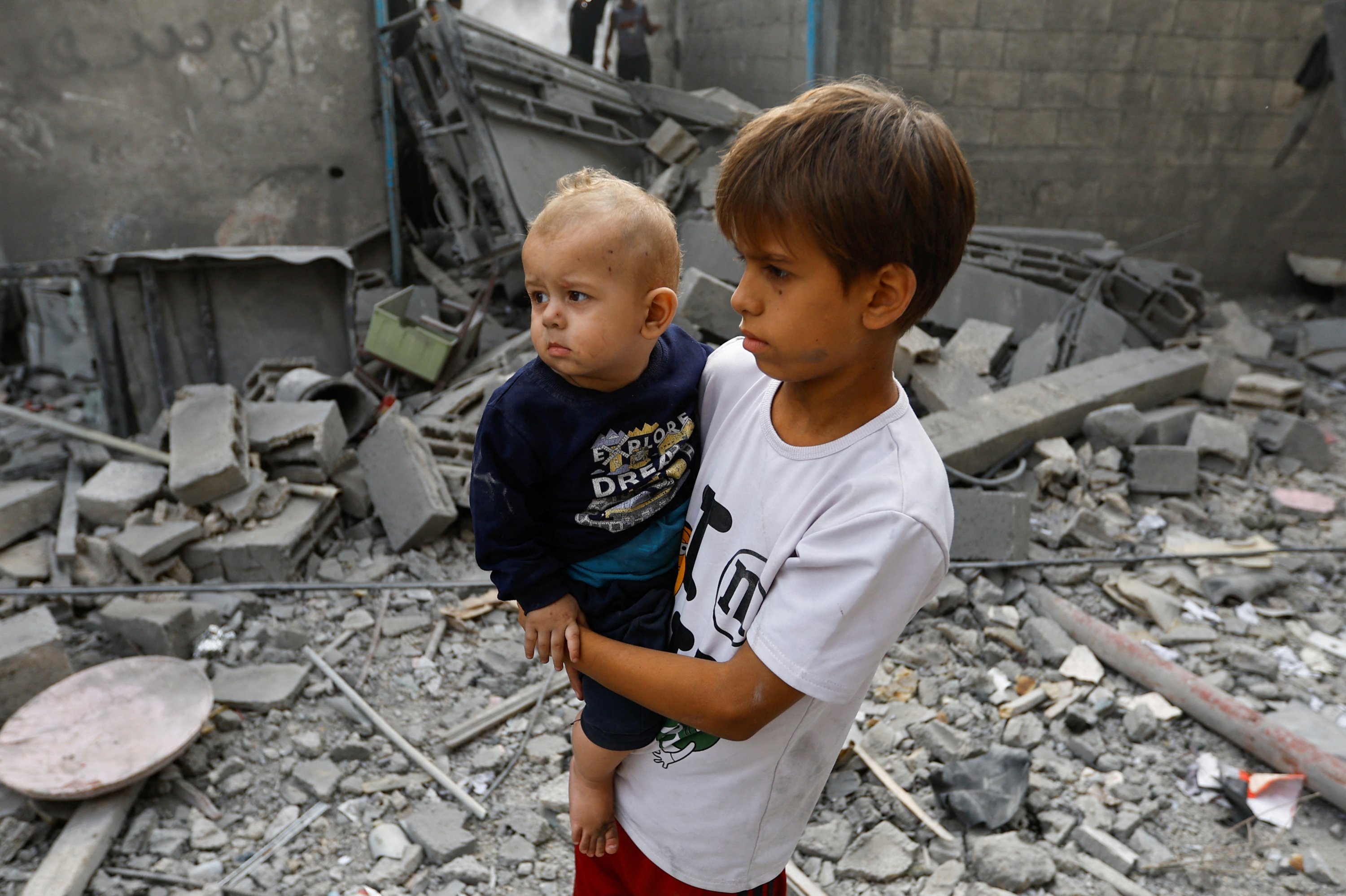 An image of Palestinian children standing among rubble